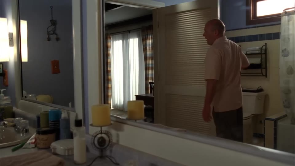 Hank in the bathroom doorway with his back to the camera